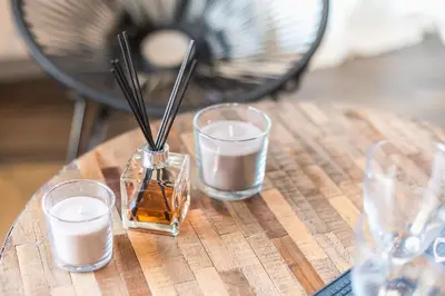 a wooden table with three glasses of milk and a candle at 