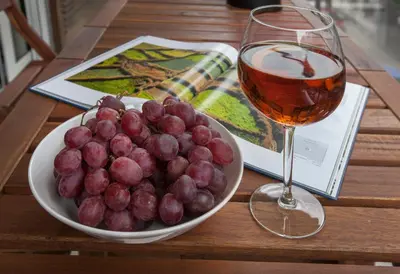 a bowl of grapes and a glass of wine on a table at Unique Apartment close to Acropolis by GHH in Athens