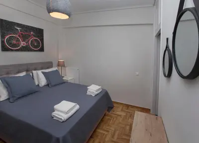 a bedroom with a bed with blue sheets and a mirror at Unique Apartment close to Acropolis by GHH in Athens