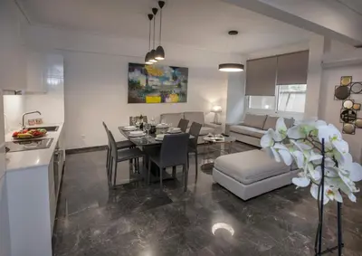 a kitchen and a living room with a table and chairs at Unique Apartment close to Acropolis by GHH in Athens