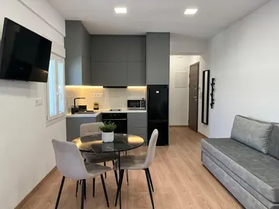 a living room with a table and chairs and a couch at Boutique Studios near Airport in Pallíni