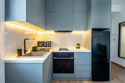 a kitchen with a sink and a black refrigerator at Boutique Studios near Airport in Pallíni