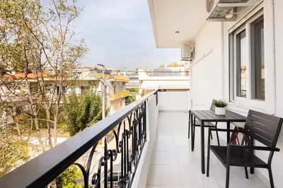 a balcony with a table and chairs on a balcony at Boutique Studios near Airport in Pallíni