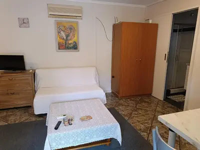 a small living room with a couch and a table at Sunny garden studio in Athens