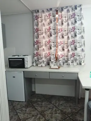 a desk with a microwave and a curtain with dogs on it at Sunny garden studio in Athens