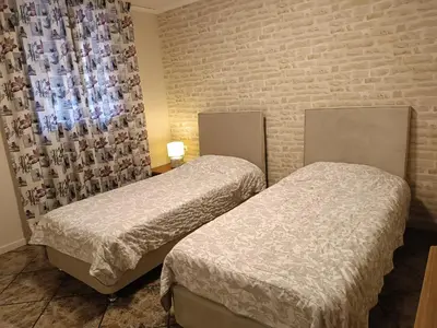 two beds in a room with a brick wall at Sunny garden studio in Athens