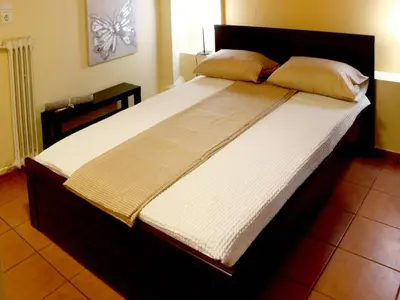 a bedroom with a large bed with white sheets at Sweet stone apartment in Imittos in Athens