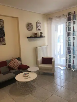 a living room with a couch and a table at Cozy studio apartment in PIREUS in Piraeus