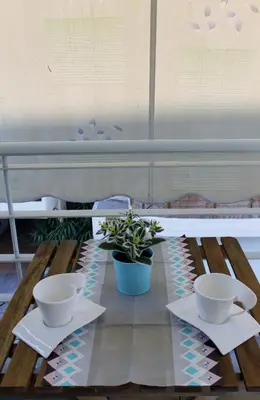 a table with two bowls and a potted plant on it at Cozy studio apartment in PIREUS in Piraeus