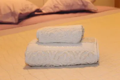 a stack of towels sitting on a bed at Cozy studio apartment in PIREUS in Piraeus