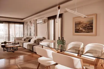 a living room with a glass table and white chairs at Grystal Green Properites in Athens