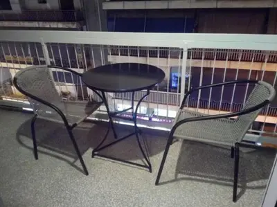 a table and two chairs next to a bird cage at Comfortable inexpensive apartmets near metro in Athens