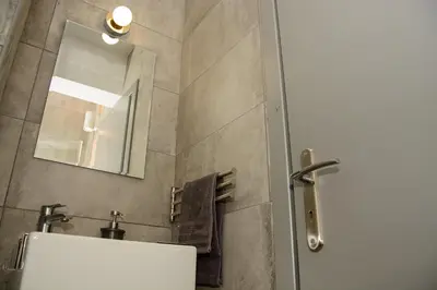 a bathroom with a sink and a mirror at Comfy brand new apt near Acropolis museum in Athens
