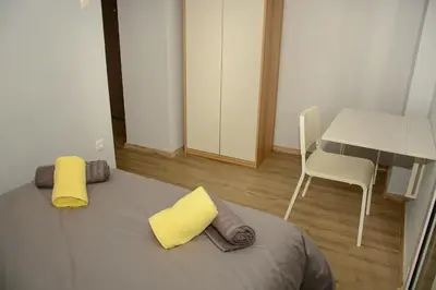 a bedroom with a bed with yellow pillows and a desk at Comfy brand new apt near Acropolis museum in Athens