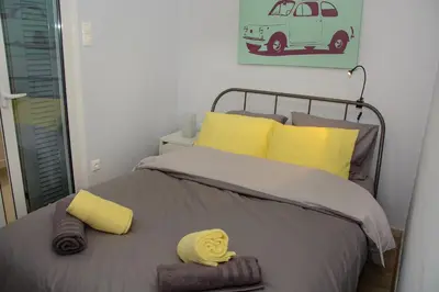 a bedroom with a bed with yellow towels on it at Comfy brand new apt near Acropolis museum in Athens