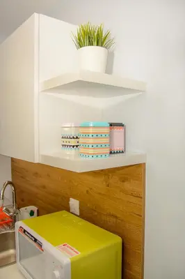 a kitchen with a shelf with bowls and a microwave at Comfy brand new apt near Acropolis museum in Athens