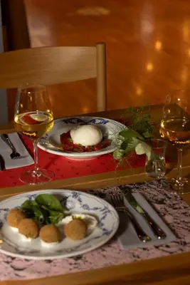 a table with two plates of food and glasses of wine at Perianth Hotel, a Member of Design Hotels in Athens