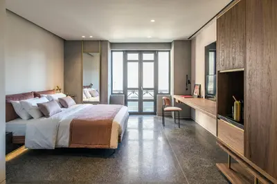 a bedroom with a bed and a desk and a television at Perianth Hotel, a Member of Design Hotels in Athens