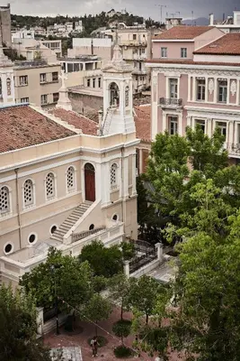 a large white building with stairs in a city at Perianth Hotel, a Member of Design Hotels in Athens