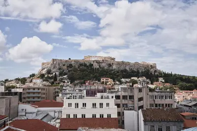a view of the acropolis from a city with buildings at Perianth Hotel, a Member of Design Hotels in Athens