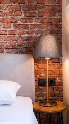 a lamp on a table next to a bed at The Athens Version Luxury Suites in Athens