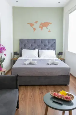 a bedroom with a bed with a tray of fruit on a table at The Athens Version Luxury Suites in Athens
