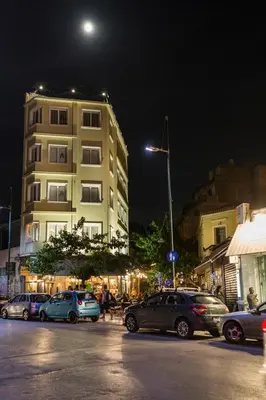 a city street with cars parked in front of a building at The Athens Version Luxury Suites in Athens