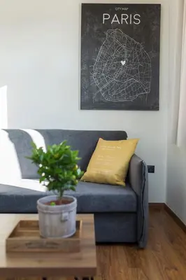 a blue couch in a living room with a potted plant at The Athens Version Luxury Suites in Athens