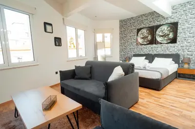 a living room with a couch and a bed at The Athens Version Luxury Suites in Athens