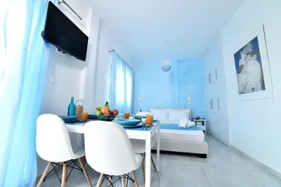 a dining room with a table and white chairs at Central Athens Studios in Athens