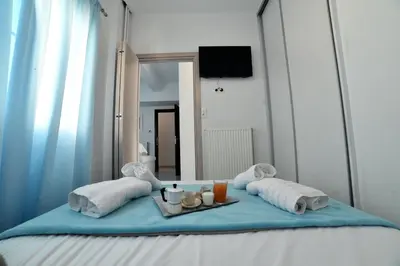 a bed with a mirror and a tray with towels and drinks at Central Athens Studios in Athens