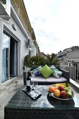 a table with a plate of fruit on a balcony at Central Athens Studios in Athens