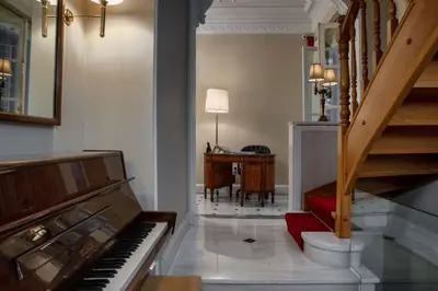 a living room with a piano and a table at Noble Suites in Athens