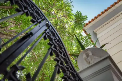 a close up of a wrought iron fence with trees in the background at Noble Suites in Athens