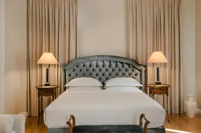 a bedroom with a large white bed with two lamps at Noble Suites in Athens