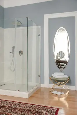 a bathroom with a shower and a round mirror at Noble Suites in Athens