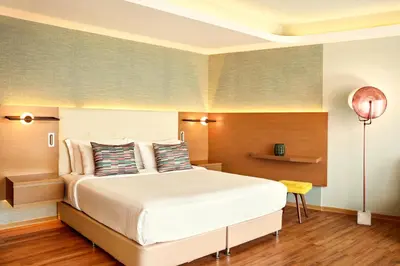 a bedroom with a large bed and a lamp at Zeus Essence Wyndham Athens Residence in Athens