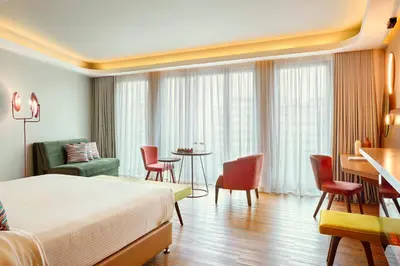 a hotel room with a bed and a table and chairs at Zeus Essence Wyndham Athens Residence in Athens