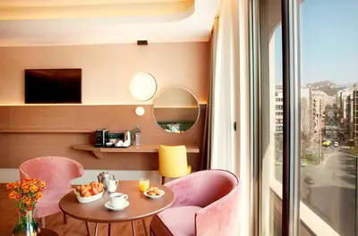 a room with a table and chairs and a window at Zeus Essence Wyndham Athens Residence in Athens