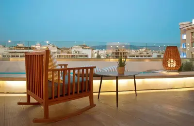 a patio with two chairs and a table on a balcony at Zeus Essence Wyndham Athens Residence in Athens