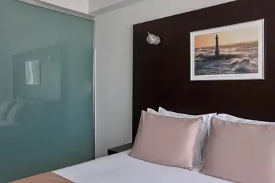 a bedroom with a bed with white pillows at Breeze Boutique Athens by Prima Hotels in Athens