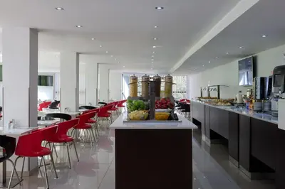 a restaurant with a row of red chairs and a counter at Breeze Boutique Athens by Prima Hotels in Athens