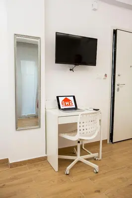 a desk with a tv and a chair in a room at Raise cosy apartment in Athens