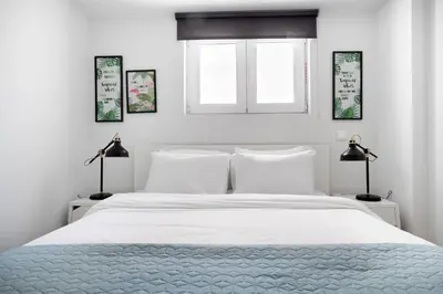 a white bedroom with a white bed and two lamps at Supreme D1 Penthouse 131m² in Syntagma in Athens