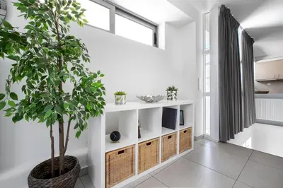 a living room with a potted tree in the corner at Supreme D1 Penthouse 131m² in Syntagma in Athens