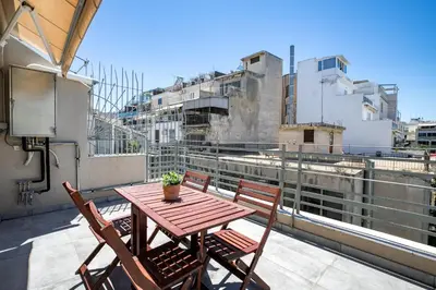 a wooden table and chairs on a balcony at Supreme D1 Penthouse 131m² in Syntagma in Athens