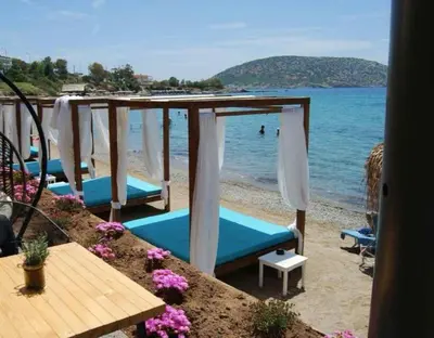 a group of umbrellas and chairs on a beach at me gusta suite by the sea in Anavissos