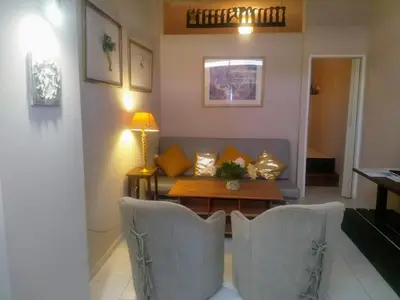 a living room with a couch and a table and chairs at me gusta suite by the sea in Anavissos