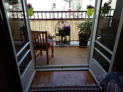 an open door to a balcony with a chair and flowers at Rooms in Central Athens in Athens