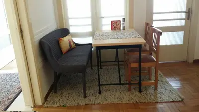 a dining room table and two chairs and a table with a pillow at Rooms in Central Athens in Athens
